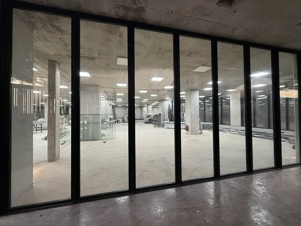 Black-framed glass wall looking into the workshop